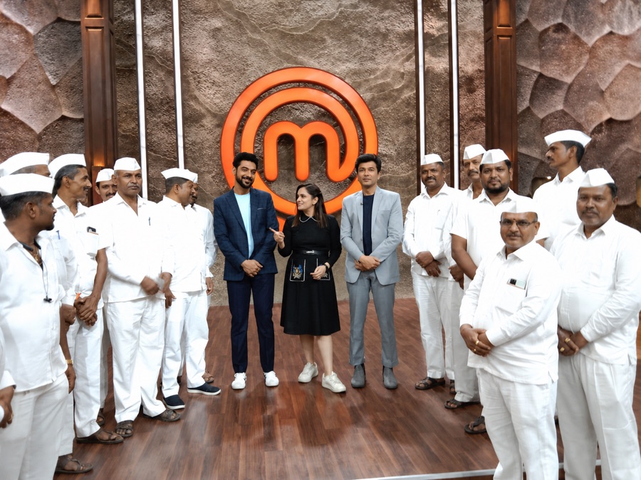 Dabbawalas lined up with presenters on a television studio set